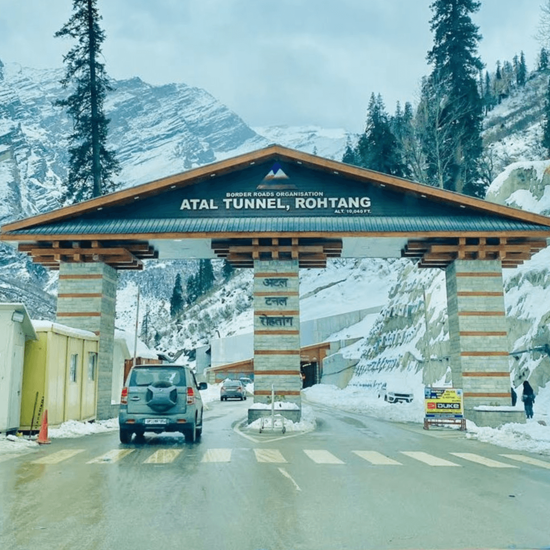 The wooden-roofed Atal Tunnel, Rohtang gateway beneath snow-dusted mountains and tall pines